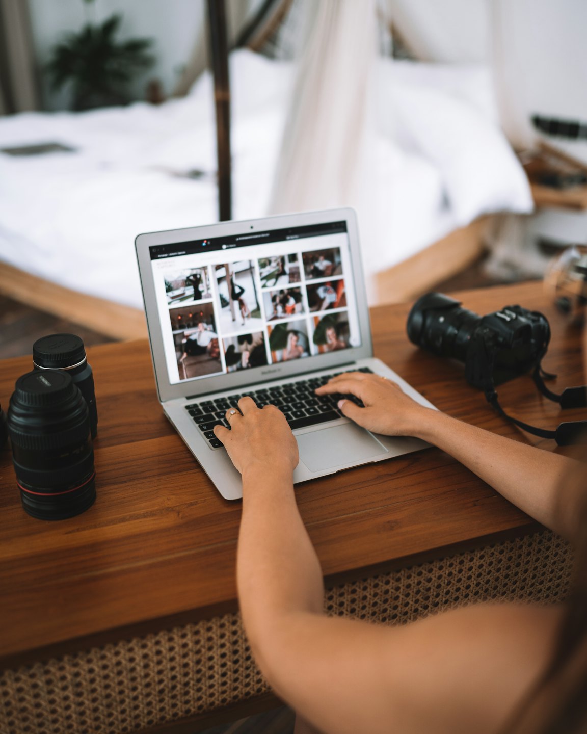 Fotograaf bekijkt foto's op een laptop aan een bureau.