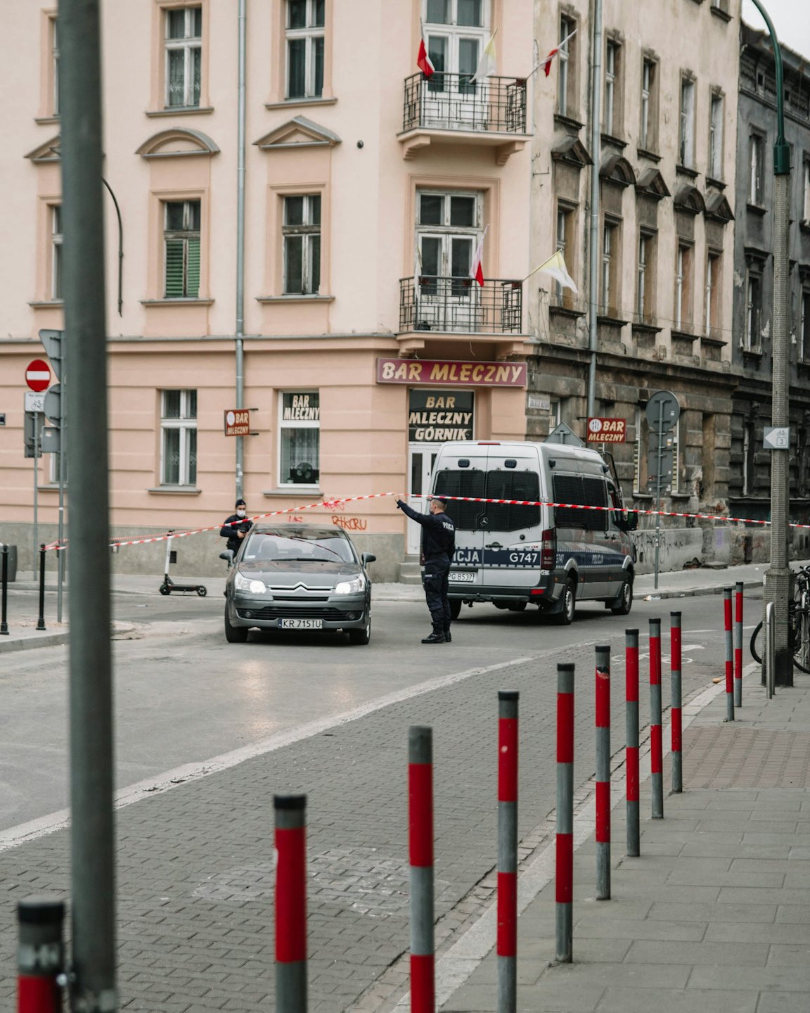 Politieagent houdt waarschuwingslint vast over een stadsstraat.