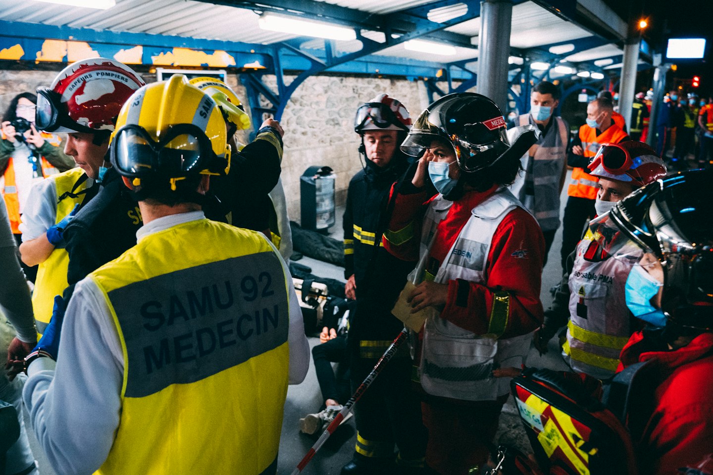 Hulpverleners met helmen en vesten bespreken een actieve respons in het donker.